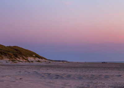 Bred strand under pastelfarvet himmel ved Vesterhavet
