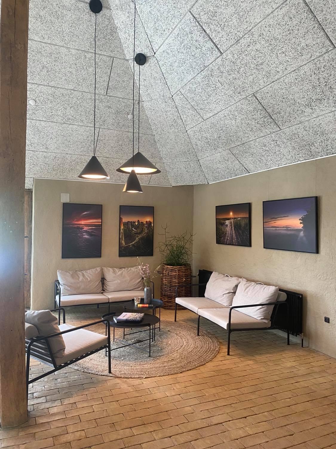 Receptionen på Marsk Camp med fotokunst over sofaerne under det høje loft Receptionen på Marsk Camp med fotokunst over sofaerne under det høje loft