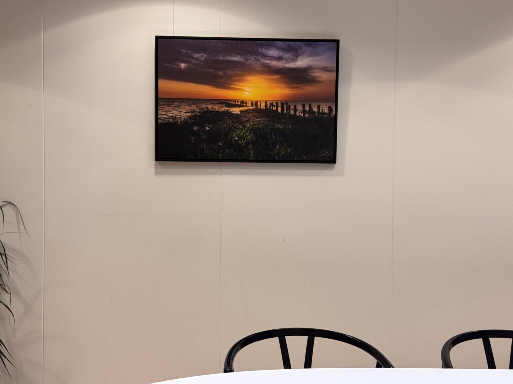 Fotografi af solnedgang over Vadehavet på væggen over et mødebord hos Norconsult
